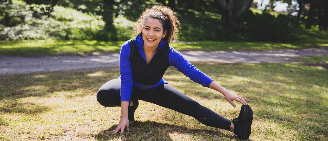 Ash London stretching in the park