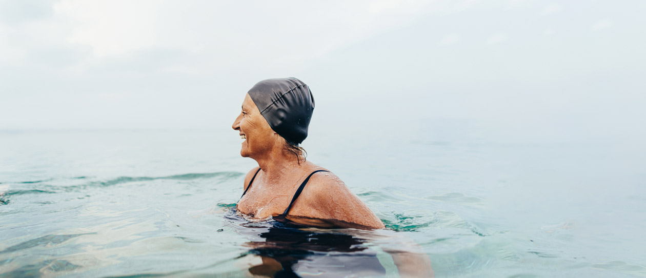 Woman in a black swimming cap enjoying an ocean swim