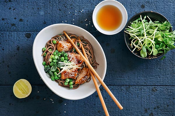 Marinated chicken with noodles, greens and lemon